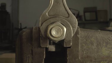 Bu video metal görevler için nasıl anahtar kullanılacağını gösteriyor, bir civatayı cıvatadan çıkarmakla başlıyor, sonra bir diğerini mengeneyle sıkıyor, ve metal bir nesneye yakın çekim ile bitiyor