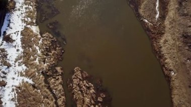 Hava görüntüsü, çamurlu bir nehri karlı bir arazide sarmalayıp gerçek güzellikleri gösteriyor. Kırp
