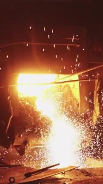 Kıvılcımlar ve ısıtmalarla çevrili canlı bir dökümhaneye dökülen erimiş metalin dinamik bir sahnesi, zanaatkarlık sergiliyor. Menkul Kıymetler