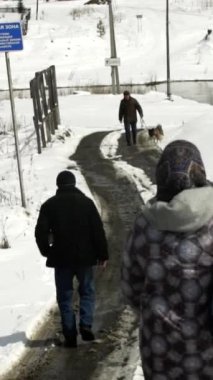 İnsanlar güzel bir kış manzarası içinde karlı bir patikada yürüyorlar, mevsimin güzelliğini vurguluyorlar. Menkul Kıymetler