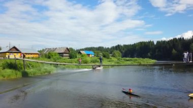 Huzurlu ve sakin bir nehir manzarası sergilenen bir kano, yemyeşil otlakların ortasında büyüleyici kır evleri ile çevrili. Menkul Kıymetler