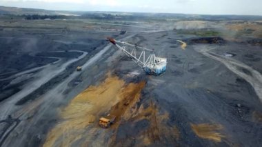 Hava perspektifi, geniş makineler ve kazılmış arazilerin yer aldığı geniş madencilik operasyonlarını güzel bir şekilde sergiliyor. Menkul Kıymetler