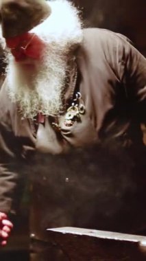 Demirhanesinde özenle çalışan yetenekli bir demirci. Etrafı çeşitli aletlerle çevrili ve dumanla kaplı. Menkul Kıymetler