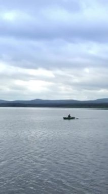 Görkemli dağların ve kabarık beyaz bulutların sardığı tamamen sakin bir göl huzuru mükemmel bir şekilde temsil eder. Menkul Kıymetler