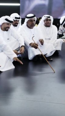 Dubai, BAE - Haziran 2024: Geleneksel Emirati kıyafeti giymiş bir grup erkek anlamlı bir kültürel tartışmaya aktif olarak dahil oldu. Medya