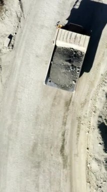 Bir kuş gözü perspektifi, ağır makineler ve çakıl arazisiyle dolu bir inşaat alanını gösteriyor. Menkul Kıymetler