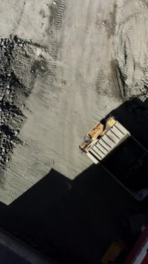 Hava görüntüsü, çeşitli makineleri ve devam eden çakıl çalışmalarının olduğu yoğun bir inşaat sahası gösteriyor. Menkul Kıymetler