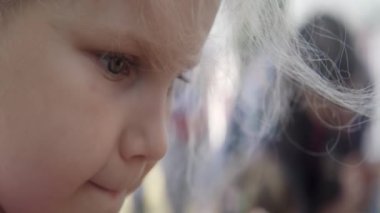 Bir çocuk, açık havada bir el işi yaratıcı sanat projesine katılırken dikkatle bu işe odaklanıyor. Eylem