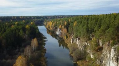 Huzurlu bir nehir, sonbahar yapraklarıyla süslenmiş canlı ve gür ormanların arasında nazikçe kıvrılır. Menkul Kıymetler