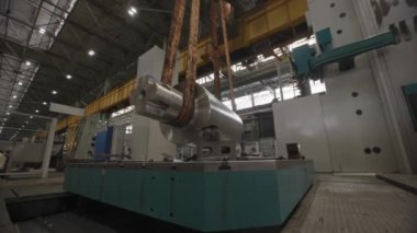 Geniş ve iyi donanımlı bir atölye ortamında gelişmiş bir endüstriyel makine kaldırılıyor. Menkul Kıymetler