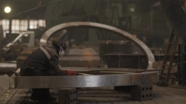 Kendini işine adamış ve yetenekli bir işçi loş bir endüstriyel atölyede karmaşık metal parçaları üretiyor. Menkul Kıymetler