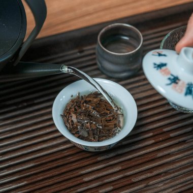 Çay demlemek, çay yapraklarını sergilemek ve geleneksel ortamında güzel bir çaydanlık için huzurlu bir an.