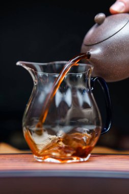 Huzurlu ve huzurlu bir an, çaydanlıktan dökülen çayı güzel bir cam sürahiye yansıtıyor.