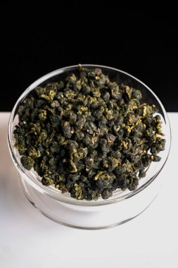 Büyüleyici bir yakın çekim kaliteli kurutulmuş bitki çayı yaprakları şık bir cam kasede güzelce yerleştirilmiş.