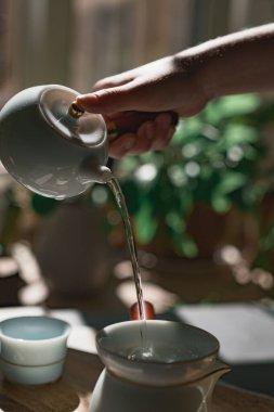 Güzel ve huzurlu bir an, çaydanlıktan bir fincana dökülen, yemyeşil bir çaydanlığı yakalıyor.