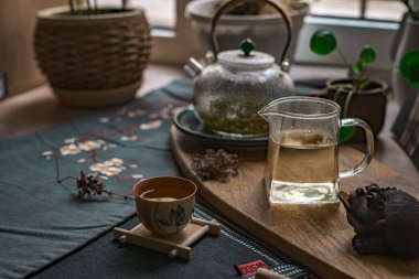 Bu dingin çay seti cam bir çaydanlık, hassas bir fincan ve rahatlatıcı bir dekor içeriyor. Rahatlamak için mükemmel.