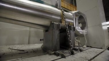 Bir CNC makinesinde büyük bir metal bileşeni gösteren makine süreci hassas mühendisliği vurguluyor. Menkul Kıymetler