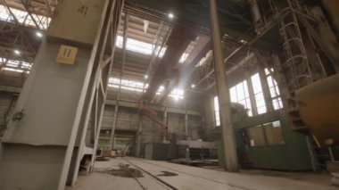 Makineleri aydınlatan güneş ışınlarıyla dolu geniş, iyi ışıklandırılmış bir fabrika ortamı. Menkul Kıymetler