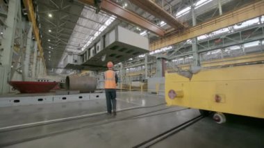 Yetenekli bir işçi, büyük bir endüstriyel tesisteki kritik ağır makineleri kaldırma operasyonlarını aktif olarak denetliyor. Menkul Kıymetler