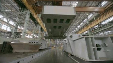 Geniş bir fabrika içi, birden fazla vinç ve ağır makineler sergileniyor. Hepsi de verimli çalışıyor. Menkul Kıymetler