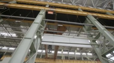 Etkileyici vinçleri ve sağlam çelik yapıyı vurgulayan büyük bir endüstriyel tesis manzarası. Menkul Kıymetler