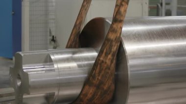 Bu, son derece cilalanmış metal silindirleri ve hassas bir mühendislik ortamında kayışları gösteren yakın çekim bir görüntü. Menkul Kıymetler