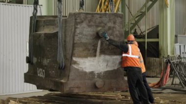 Hareketli bir endüstriyel ortamda, yetenekli bir işçi, ekipmanları verimli bir şekilde kaldırmak ve idare etmek için ağır makineler kullanır. Menkul Kıymetler