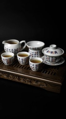 Geleneksel bir Çin çay seti çok güzel sergilenir, ılık çay seremonisi için mükemmel olur.