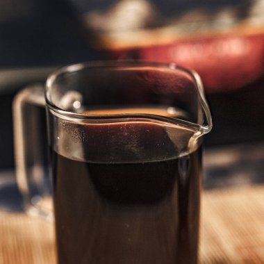 Koyu bir sıvıyla dolu parlak bir cam sürahi. Hem kahve hem de çay meraklıları için mükemmel.