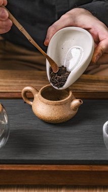 Çayın çeşitli çeşitleri güzel bir el yapımı çaydanlığa, demlenmek için güzelce dökülüyor.