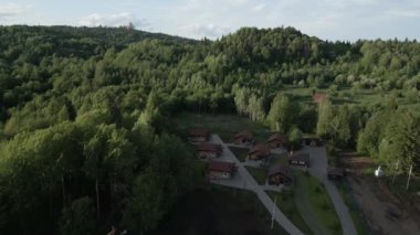 Serin bir hava manzarası, yemyeşil alanlarda büyüleyici kır kulübelerinin yer aldığı güzel bir orman inzivası sergiliyor. Kırp