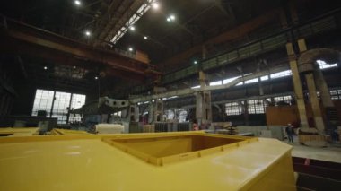 Etkileyici derecede geniş bir sanayi deposunda ağır makineler ve çeşitli ekipmanlar kullanılıyor. Menkul Kıymetler