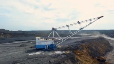 Geniş bir açık çukur mayın alanında özenle çalışan büyük bir kazıcıyı güzelce gösteren bir hava manzarası. Menkul Kıymetler