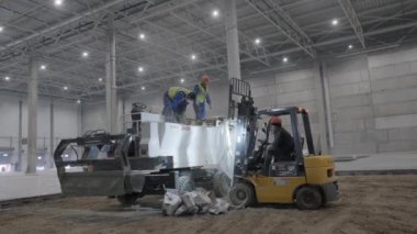 Gürcistan, Tiflis - 7 Kasım 2024: İşçiler yoğun bir inşaat sahasında, takım çalışması ve adanmışlığı gösteren ağır makineler kullanıyorlar