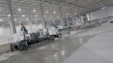 Gürcistan, Tiflis - 7 Kasım 2024: Şu anda inşaat halindeki çağdaş bir depo, beton döşemek için çalışan çeşitli makineleri gösteriyor