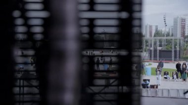 Gürcistan, Tiflis - 20 Temmuz 2024: Dışarıdaki kentsel toplanma olayının biraz bulanık bir görüntüsü, çizgili bir pencere panelinden görülüyor