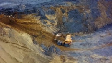 Bir maden kamyonu yoğun bir taş ocağında hareket ederek makinelerin etkileyici gücünü gösteriyor. Menkul Kıymetler