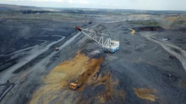 Hava perspektifi, bir kömür madeninde endüstriyel faaliyetleri vurgulayan ağır makineler gösteriyor. Menkul Kıymetler