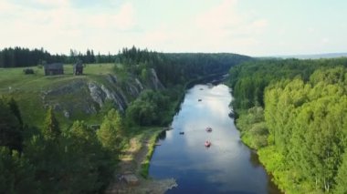 Canlı yeşillik ve kayalık uçurumlarda usulca kıvrılan sakin ve güzel bir nehri görüntüleyen bir hava manzarası. Menkul Kıymetler