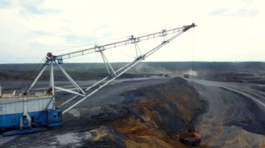 Açık bir maden sahasında çalışan büyük bir kazıcının hava görüntüsü önemli endüstriyel faaliyetleri vurguluyor. Menkul Kıymetler