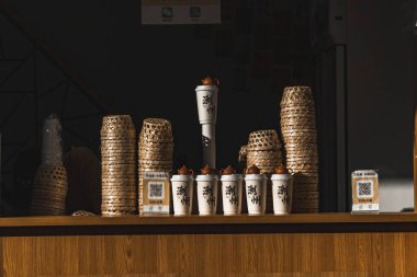 Kahve fincanları ve kaplardan oluşan şık bir karışım, davetkar bir kafe atmosferi sergiliyor.