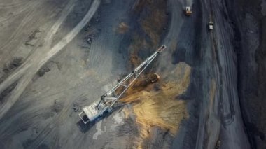 Bir maden çıkarma sahasında aktif olarak çalışan ağır madencilik makinelerini vurgulayan bir hava perspektifi. Menkul Kıymetler