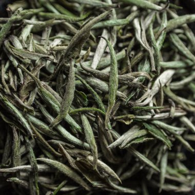 Özel kurutulmuş yeşil çay yapraklarının detaylı bir görüntüsü eşsiz dokusunu ve canlı rengini gözler önüne seriyor.