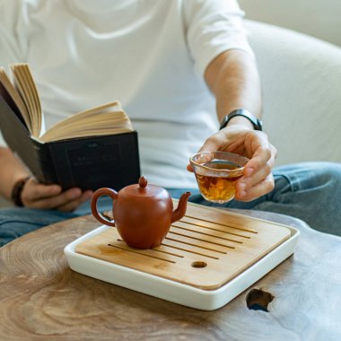 Huzurlu bir çay saati sahnesi ve büyüleyici bir kitap okumak, rahatlama ve farkındalık için mükemmel.