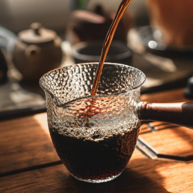 Güzel desenli cam sürahiye dökülen taze kahvenin büyüleyici ve estetik bir görüntüsü.