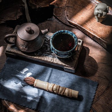 Zarif bir çaydanlık, narin bir fincan ve el yapımı aksesuarlı ılık doğal ışık ile sakin bir çay takımı.