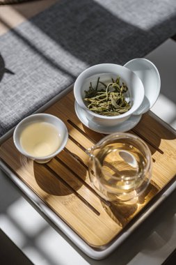 Huzurlu bir çay seti taze demlenmiş yeşil çay ve bambu tepsisi üzerinde yapraklar, rahatlamak için mükemmel.