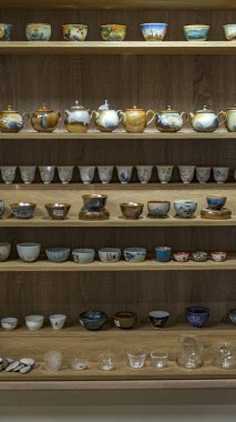 Nazikçe dizayn edilmiş çay fincanları eşliğinde ahşap raflarda harika bir koleksiyon.