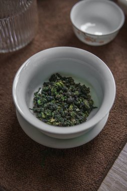 Kendinizi taze organik yeşil çay yapraklarının zengin özüne daldırın. Geleneksel kase düzeninde güzelce servis edilir.