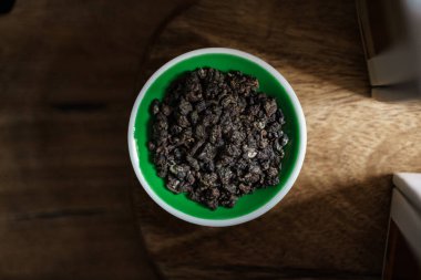 Hava manzarası, canlı, kurumuş otları, kırsal ahşap bir yüzey üzerinde ustalıkla yerleştirilmiş yeşil bir kasede yakalar.